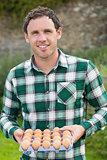 Young man holding carton of eggs