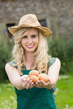 Young blonde woman showing eggs