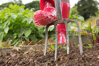Woman wearing red rubber boots working in the garden