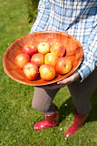 Woman holding a bowl of fresh apples
