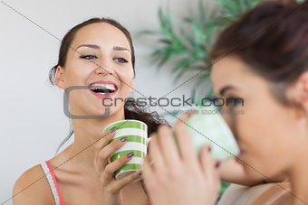 Young laughing woman having coffee with friend