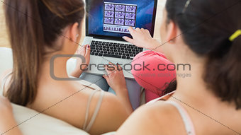 Two brunette young women working with a laptop