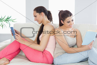 Two beautiful young women sitting on a sofa