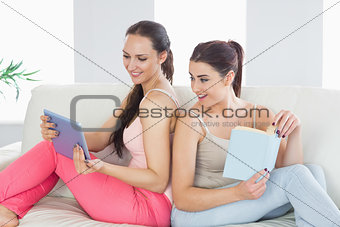 Beautiful woman showing her tablet to her friend