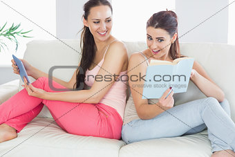 Pretty woman showing her book to her friend
