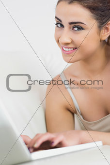 Beautiful woman smiling at the camera using her laptop