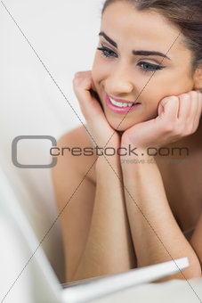Beautiful woman smiling at her laptop