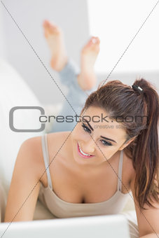 Glad brunette woman lying on a couch