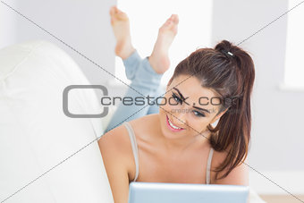 Glad young woman lying in the living room