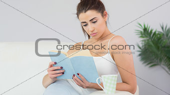 Concentrated young woman reading a book