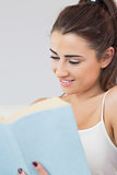 Young woman reading her book and smiling