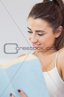 Young woman reading her book and smiling