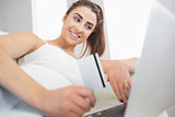 Cheerful young woman using her notebook for online shopping