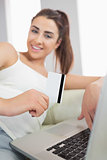 Beautiful young woman using her notebook for online shopping