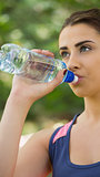 Fit cute woman wearing sportswear drinking from bottle