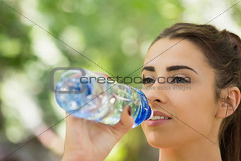 Fit cute woman drinking from sports bottle