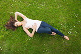 Beautiful brunette woman lying on grass