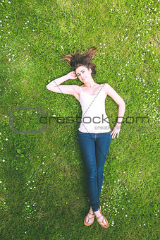 Cute brunette woman lying on a lawn