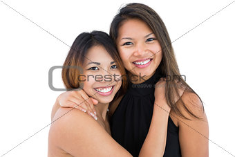 Two dressed up asian sisters embracing