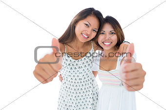 Two pretty young women showing thumbs up