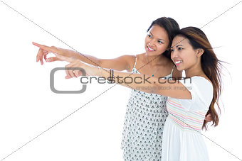 Two pretty young asian women pointing