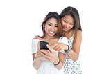 Two young sisters using smartphone