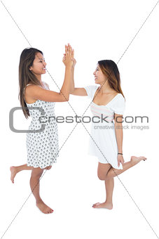 Two smiling young women high fiving