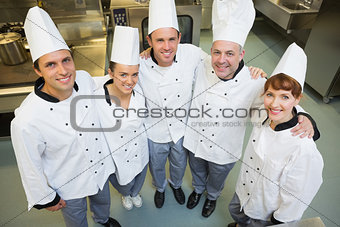 Five happy chefs smiling up at the camera