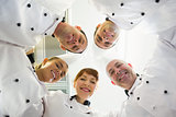 Five smiling chefs standing in a circle