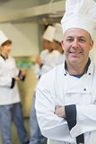 Smiling mature chef posing in a kitchen