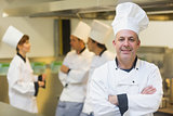 Mature male chef posing proudly in a kitchen