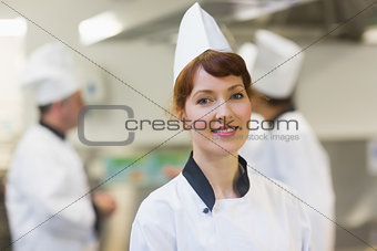 Smiling female chef posing in a kitchen