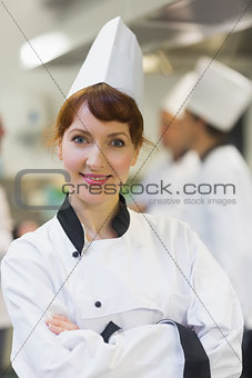 Female chef posing proudly in a kitchen
