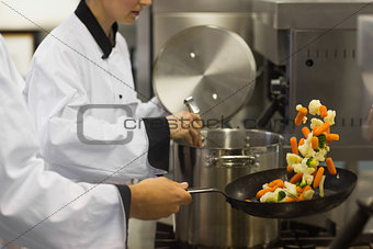 Two chefs working in a busy kitchen