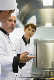 Male mature chef explaining something to a colleague