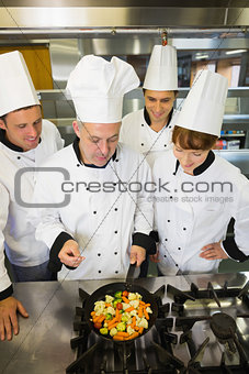Experienced head chef explaining something to his colleagues
