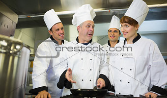 Experienced head chef explaining food to his colleagues