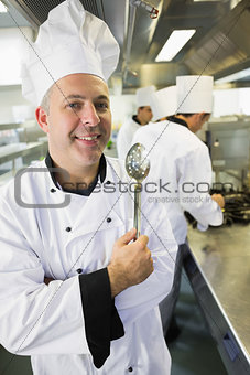 Senior chef posing proudly in a kitchen
