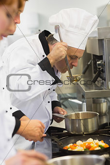 Three chefs working at the stove