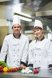 Two young chefs posing in a kitchen