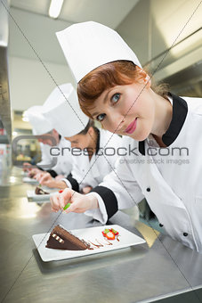 Happy chef garnishing dessert plate