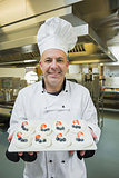 Mature chef presenting proudly plate of meringues
