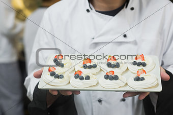Chef presenting plate of meringues
