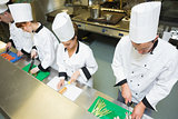 Four chefs preparing food at counter