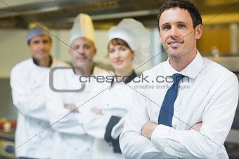 Young restaurant manager posing in front of team