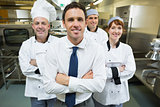 Restaurant manager posing in front of team of chefs