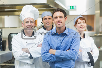 Young manager posing with some chefs