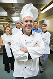 Head chef posing with his team behind him