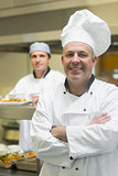 Happy mature head chef posing with crossed arms