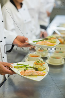 Chef holding salmon dish
